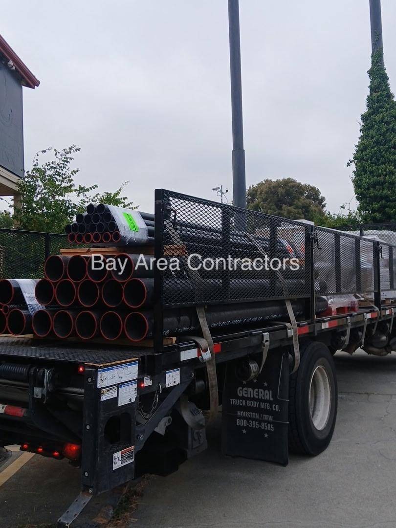 Flatbed truck loaded with cast iron and ABS pipe for a plumbing rough
