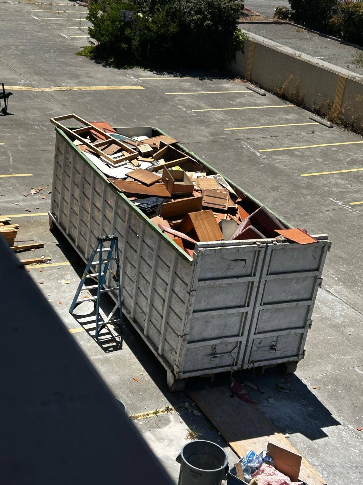 Roll-off debris box loaded with demolition material at a commercial property